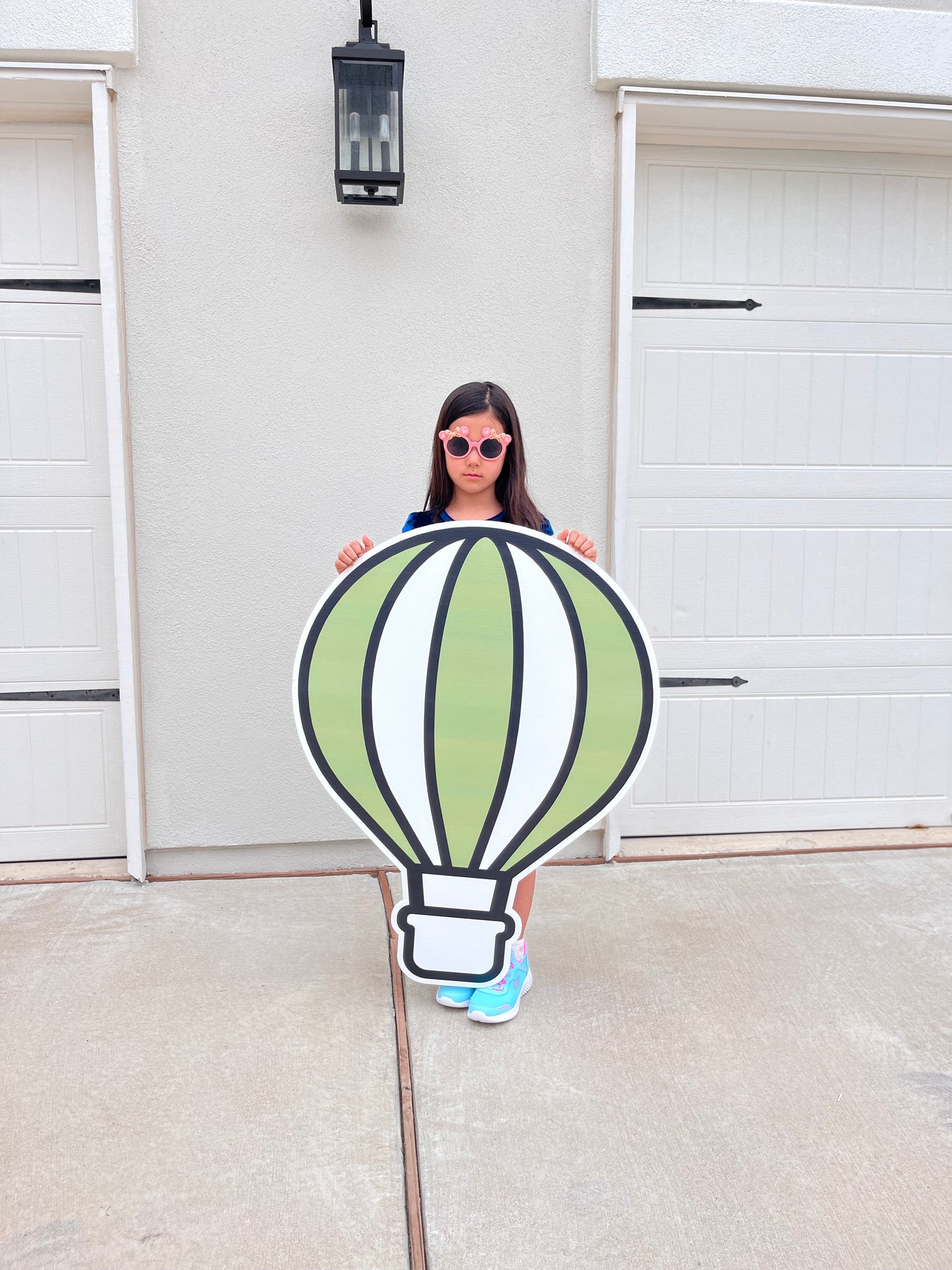 Person holding a cutout of a hot air balloon in front of a door event decor character props cutout life size