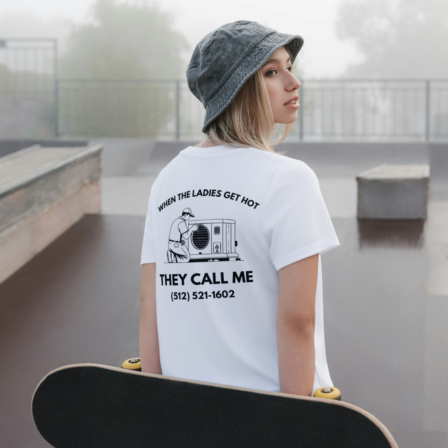 Person wearing a white t-shirt with text and a phone number, holding a skateboard in an outdoor setting. Men women unisex sized Funny tshirt, fun t shirt, when the ladies get hot, when the ladies got hot, they call me, all terrain HVAC jokes, HVAC contractor shirts