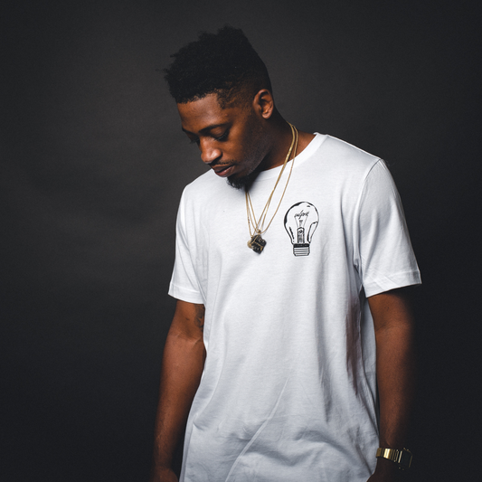 A man wearing a white customized t-shirt with a logo on the front left chest. Custom t-shirt, personalized design, men’s/unisex fit, front/back view